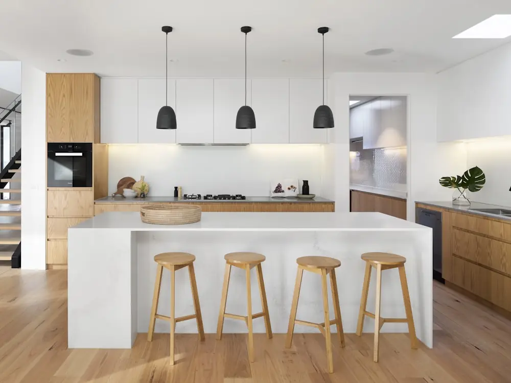Modern white kitchen with a waterfall quartz island in Etobicoke