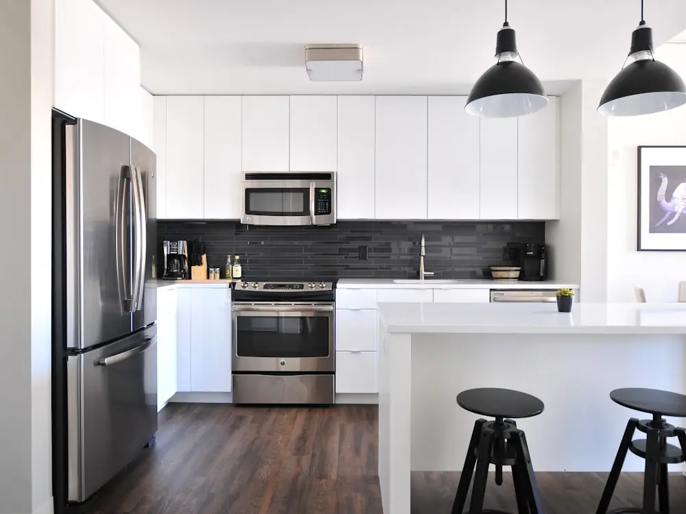 Compact modern kitchen with stainless appliances and black pendants