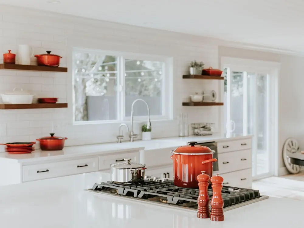 Classic white kitchen with open shelving and a gas range in Toronto