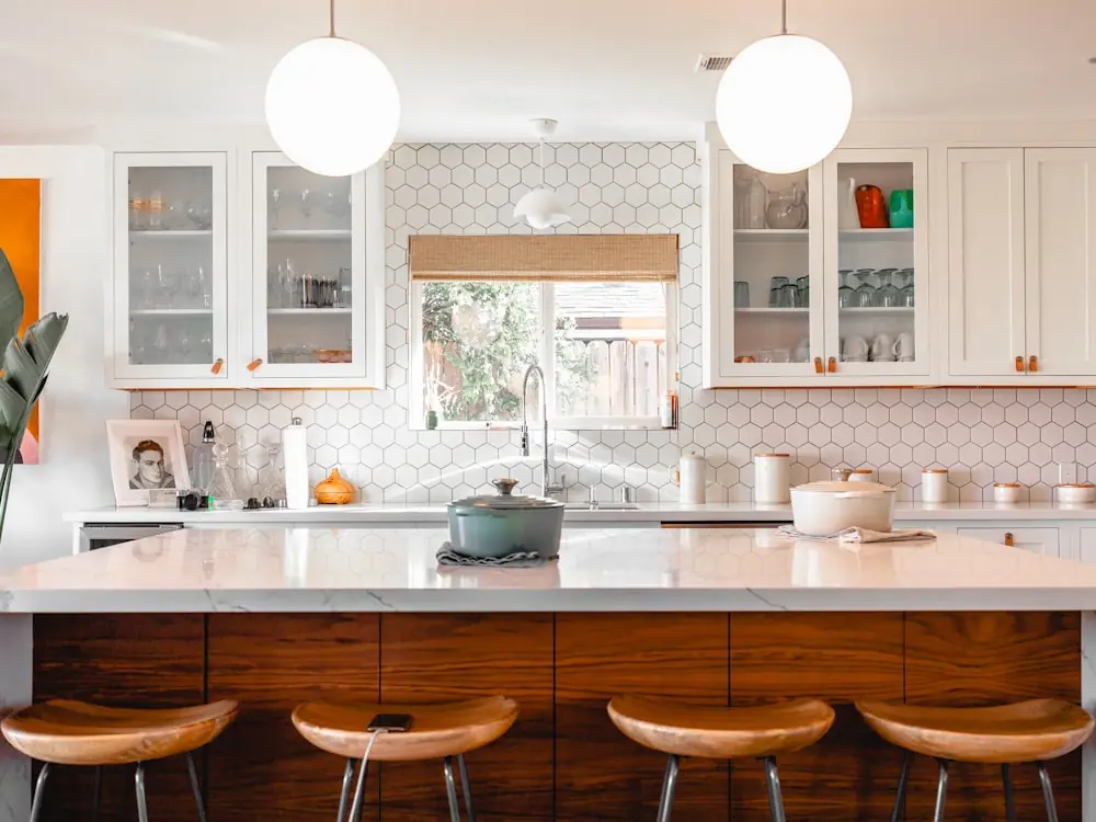 Kitchen island with wooden bar stools and warm task lighting